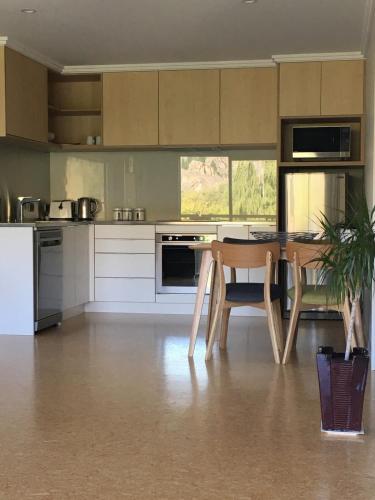 a kitchen with a table and a table and chairs at Clock view Apartment in Alexandra