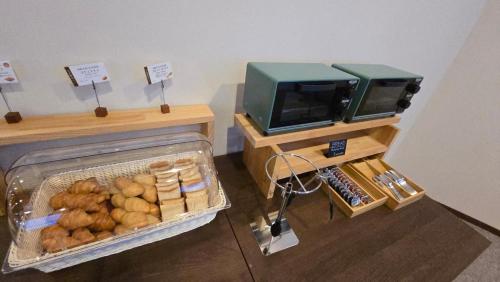 a room with a tv and a basket of food at Hotel Cerulean Alpine in Otari