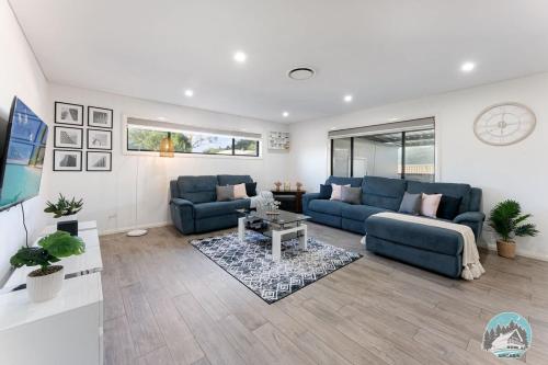 a living room with two blue couches and a table at Aircabin - Guildford - 3 Beds Spacious House in Guildford