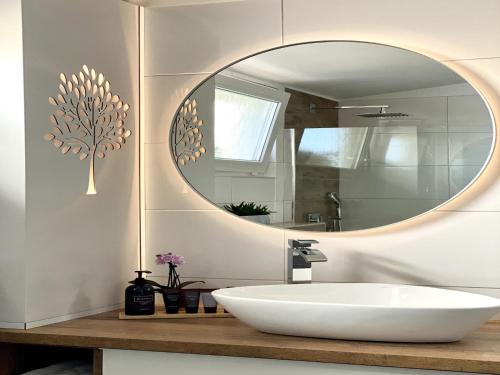 a bathroom with a white sink and a mirror at Villa in Doksy near Macha Lake in Doksy