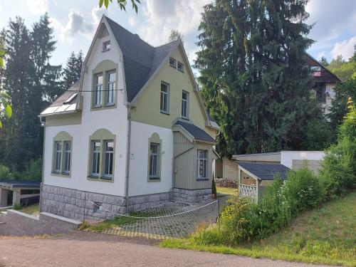 a white house with a black roof at Villa in Jablonec with Sauna & Hot Tub in Albrechtice v Jizerských horách