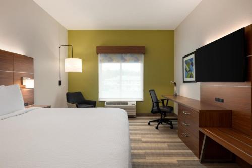 a room with a bed and a desk and a television at Holiday Inn Express & Suites - Dalton - Walnut Ave by IHG in Dalton