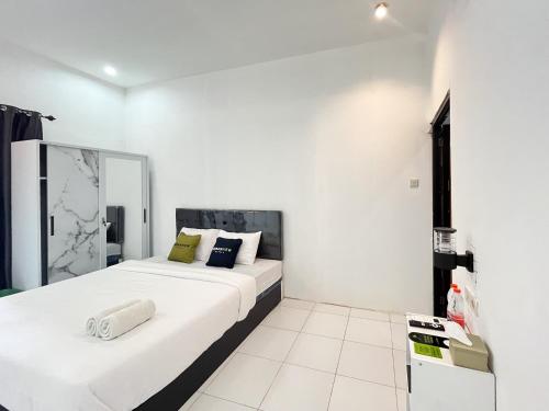 a white room with a large bed in it at Urbanview Trunojoyo Homestay Banyuwangi by RedDoorz in Banyuwangi