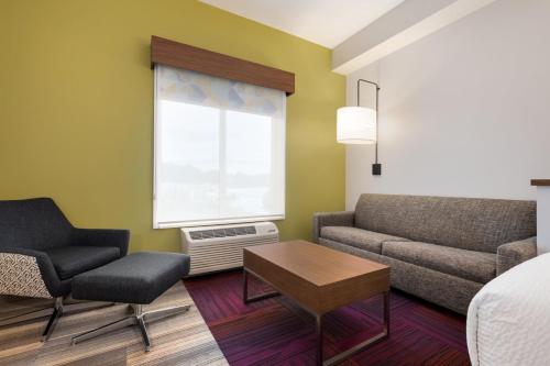 a room with a bed and a couch and a table at Holiday Inn Express & Suites - Dalton - Walnut Ave by IHG in Dalton