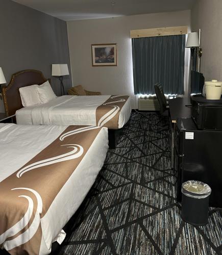 a hotel room with two beds and a desk at Hometown Inn Indian River in Indian River