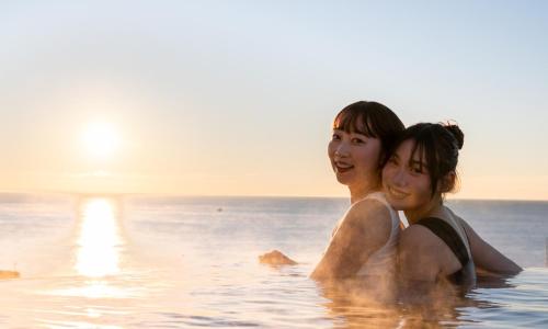 two children standing in the water in the ocean at Oiso Prince Hotel in Oiso
