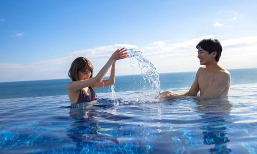 a man and a little girl playing in the water at Oiso Prince Hotel in Oiso