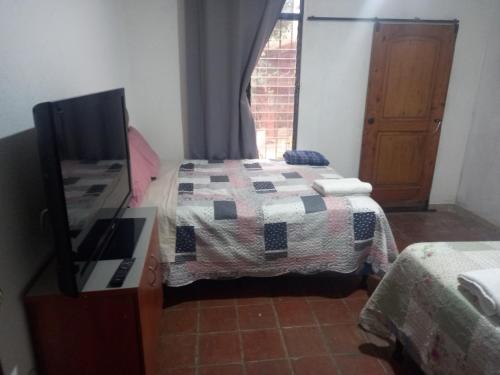 a bedroom with a bed and a tv and a window at Apartamento The River in Panajachel