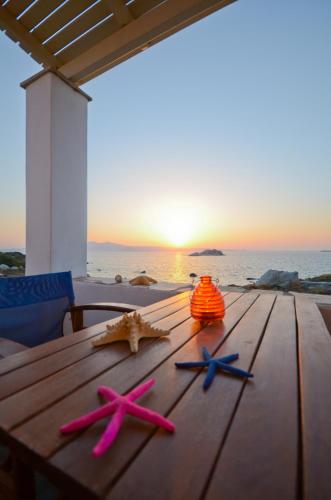 four starfish on a wooden table on the beach at Ydreos Studios & Apartments in Mikri Vigla