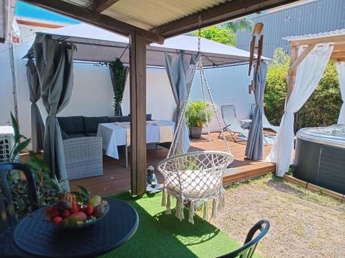 a patio with a swing and a table with a bowl of fruit at Caz A Mwa in Saint-Joseph