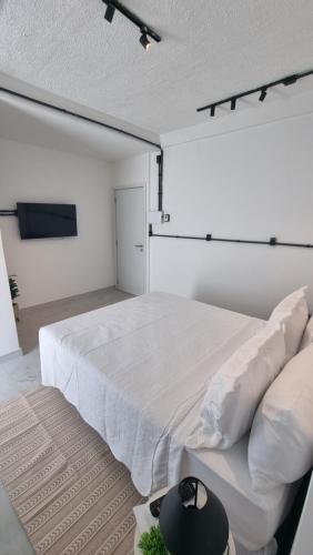 a bedroom with a large white bed and a rug at Hotel Pousada Villas do Atlântico in Lauro de Freitas