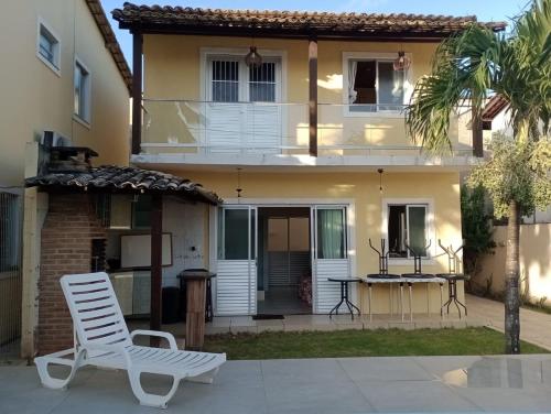 a white chair sitting in front of a house at Refúgio Verde in Camaçari
