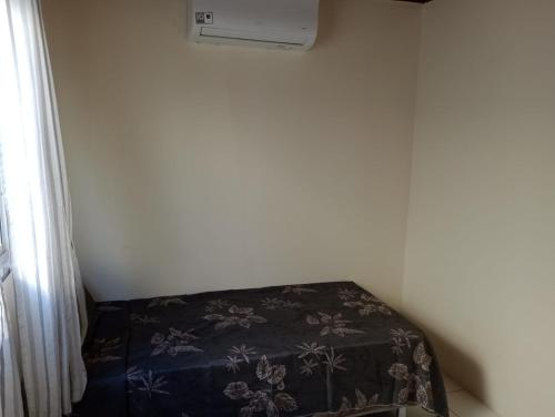 a room with a bed with a blanket on it at Refúgio Verde in Camaçari