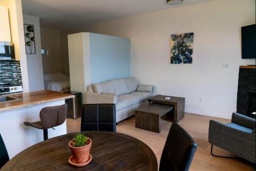 a living room with a couch and a table at Catch of the Day- Waterfront Bachelor Condo in Tofino