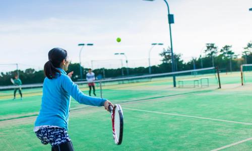a group of people playing tennis on a tennis court at Oiso Prince Hotel in Oiso