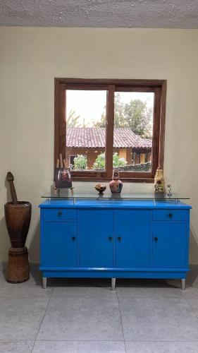 a blue dresser in a room with a window at Pousada Maria Moura in Camacari
