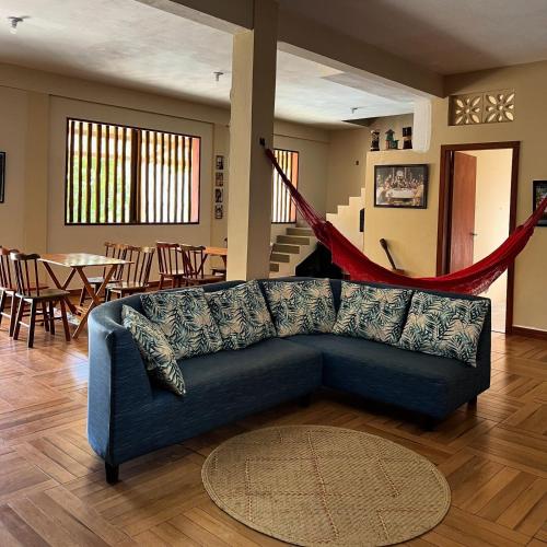 a living room with a blue couch and a table at Pousada Maria Moura in Camacari
