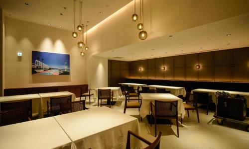 a restaurant with tables and chairs and a painting on the wall at Oiso Prince Hotel in Oiso