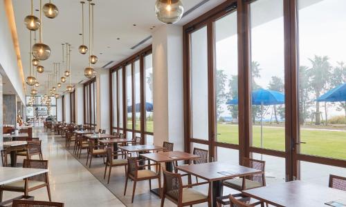 a row of tables and chairs in a restaurant with windows at Oiso Prince Hotel in Oiso