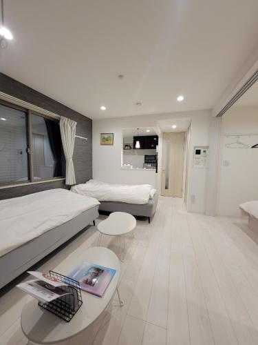 a hotel room with two beds and a table at ローズパーク八番館 in Tokyo