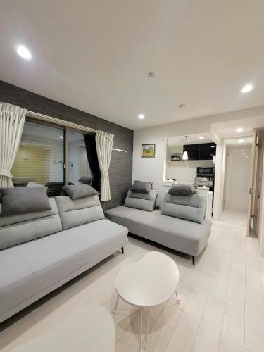 a living room with two couches and a table at ローズパーク八番館 in Tokyo