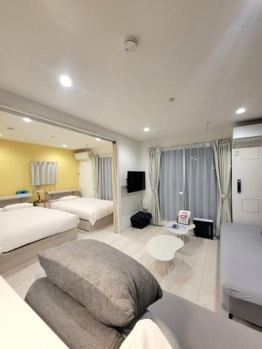 a hotel room with two beds and a couch at ローズパーク八番館 in Tokyo