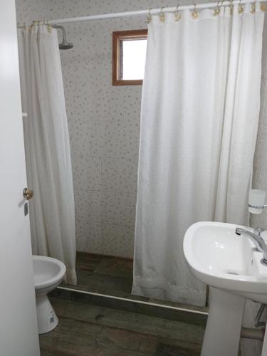 a bathroom with a white shower curtain and a sink at Casa de campo in Mar del Plata
