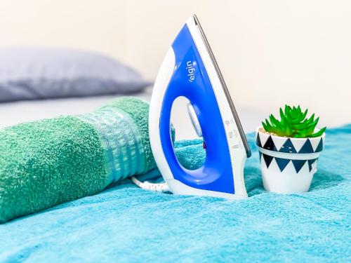 a pair of scissors sitting on a bed with a plant at Vila Imper Host Itz - Apês com Wi-fi I A/C a 5 min. do Imperial Shopping in Imperatriz