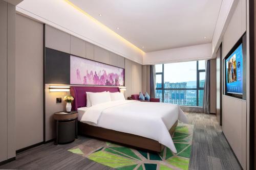 a hotel room with a bed and a tv at Hampton by Hilton Zhangjiajie Tianmen Mountain in Zhangjiajie