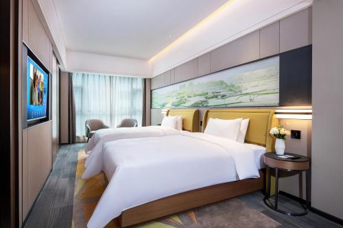 a hotel room with two beds and a painting on the wall at Hampton by Hilton Zhangjiajie Tianmen Mountain in Zhangjiajie