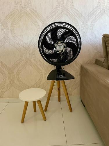 a fan sitting on a stand next to a chair at Charmosa Cobertura 1103B in Maceió