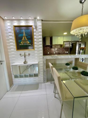 a dining room with a glass table and a view of the eiffel tower at Charmosa Cobertura 1103B in Maceió