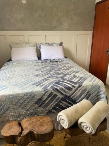 a bed with two pillows and two logs on it at Apartamento no Centro in Palmas