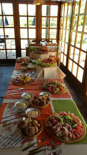 a long table with many plates of food on it at Hotel La Posta del Dayman in Termas del Daymán