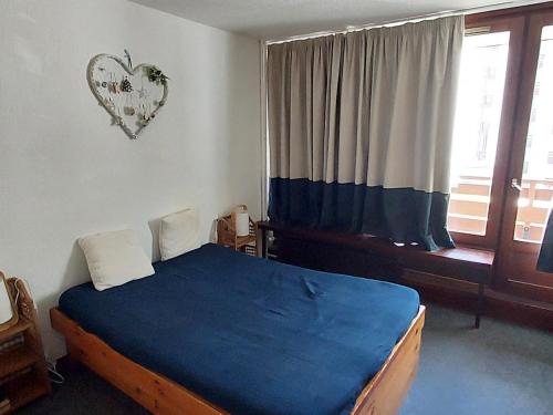 - une chambre avec un lit et une fenêtre avec un cœur sur le mur dans l'établissement Appartement 2 pièces Tignes - Balcon, WIFI, 41m² - FR-1-449-194, à Tignes