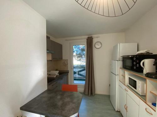 Il comprend une cuisine équipée d'un réfrigérateur et d'une fenêtre. dans l'établissement Appartement cosy au port de Capbreton avec parking privé et animaux acceptés - FR-1-413-251, à Capbreton