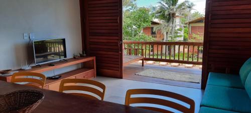 a living room with a television and a table and chairs at Cond ReservaTaipu, apart 202 in Barra Grande