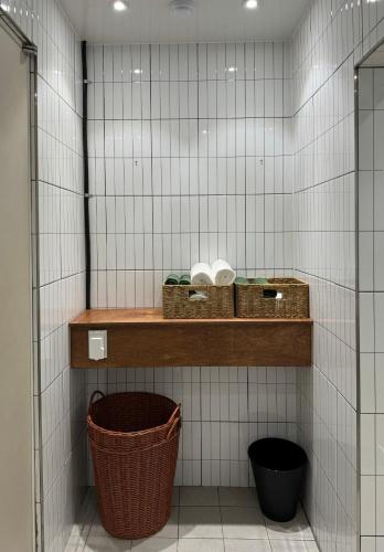 a bathroom with two baskets on a shelf in a tiled wall at DADU House in Seoul