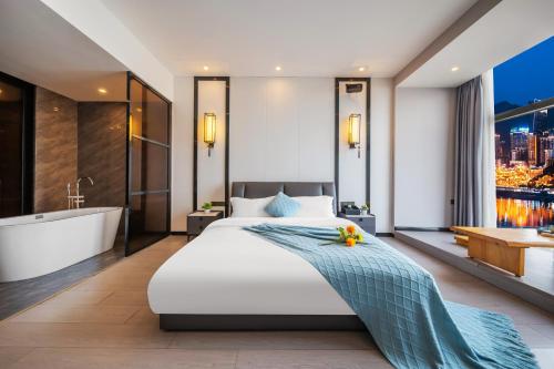重慶市にあるYunmu International Hotel Chongqing Beibin Road Branchのベッドルーム1室(大型ベッド1台、バスタブ、シンク付)