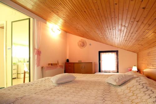 a bedroom with a large bed with a wooden ceiling at Apartment Ruža 2021 in Premantura