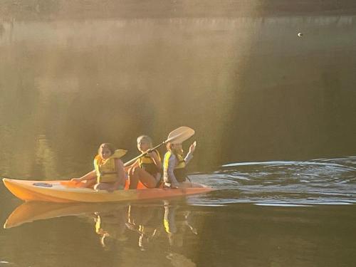 three people sitting on a kayak in the water at Evedon Lakeside Retreat in Burekup