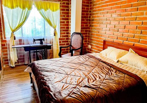 a bedroom with a bed and a brick wall at Finca San Pedro in Hacienda Santa María