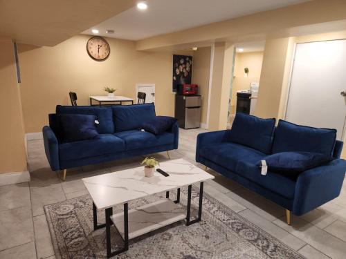 a living room with two blue couches and a table at 2kings Apartment in Newark