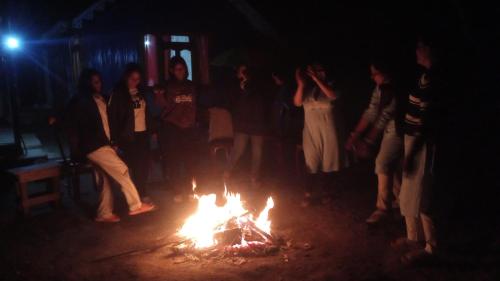 a group of people standing around a bonfire in the dark at Grace Garden Homestay in Darjeeling