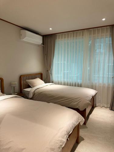 a bedroom with two beds and a window at DADU House in Seoul