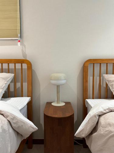 a room with two beds and a table between two beds at DADU House in Seoul