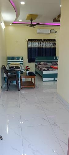 a room with two beds and a table in it at Sagar Homestay Hampi in Hampi