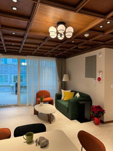 a living room with a green couch and chairs at DADU House in Seoul