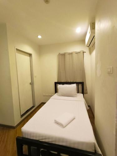 a small room with a bed with a mirror at Vinary Hotel Sukhumvit in Bangkok