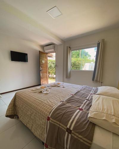 a bedroom with a large bed and a window at iapôi Beira-Mar Maracaípe in Porto De Galinhas
